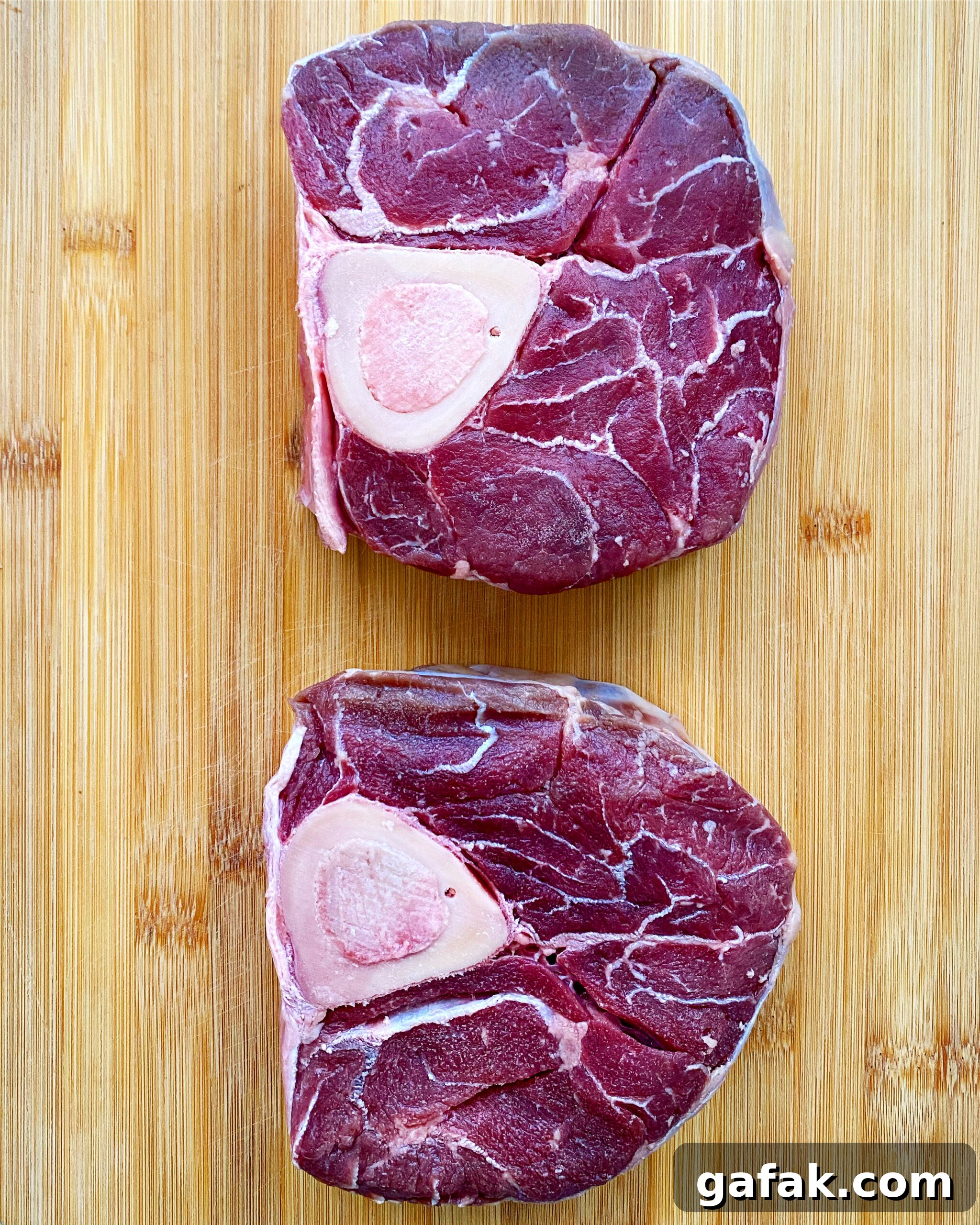 2 raw beef shanks on a wooden cutting board
