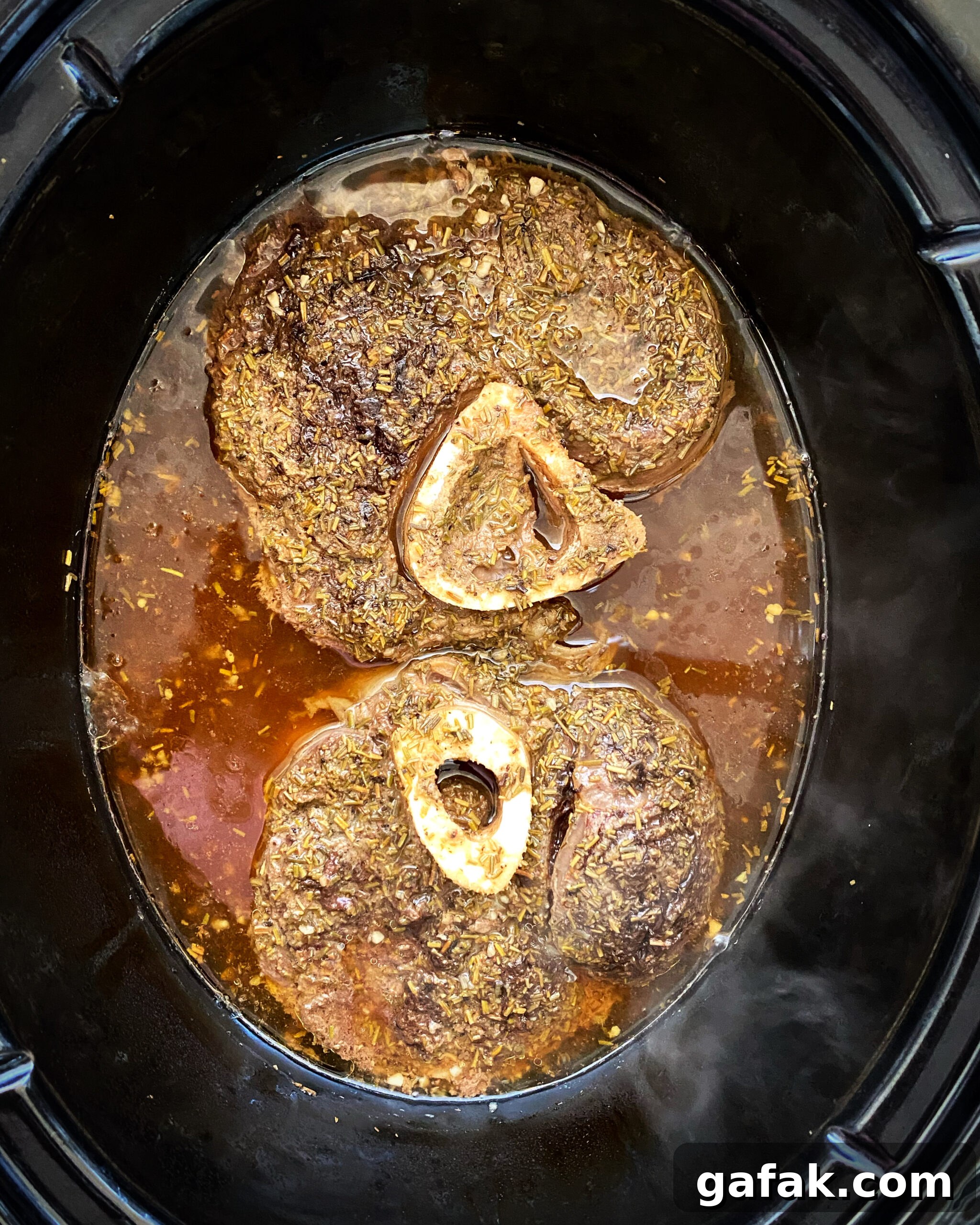 overhead shot of cooked beef shanks in a black crockpot