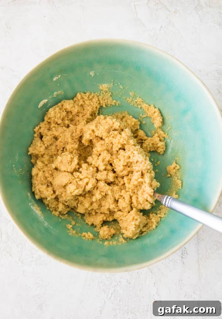 A bowl filled with raw cookie dough with a spoon in it.