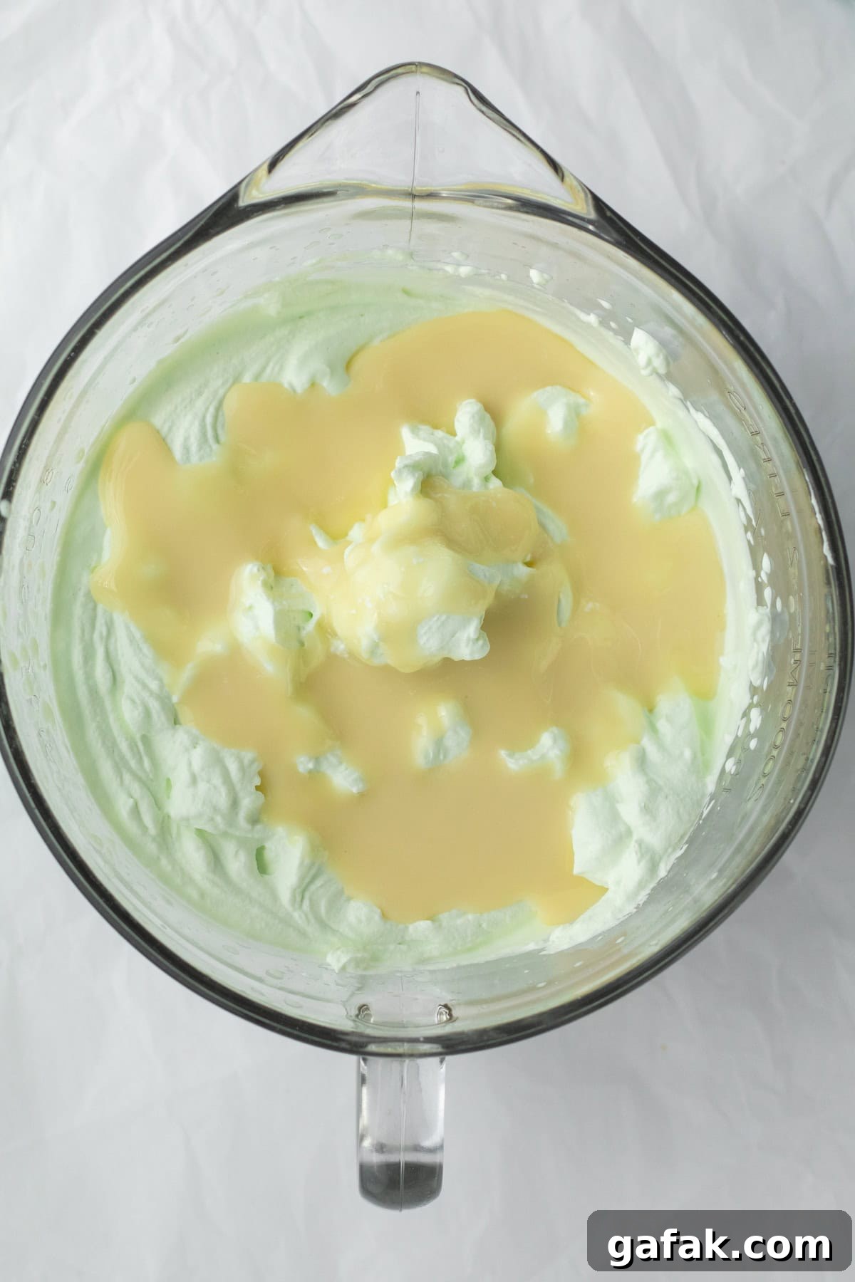 sweetened condensed milk being added to whipped cream base