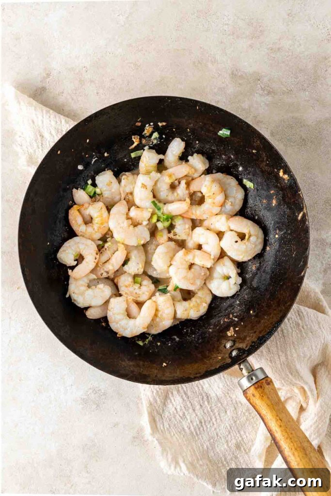 Garlic Prawn Egg Fried Rice Recipe for Quick Weeknight Meals 7 Cooking prawns in a wok.