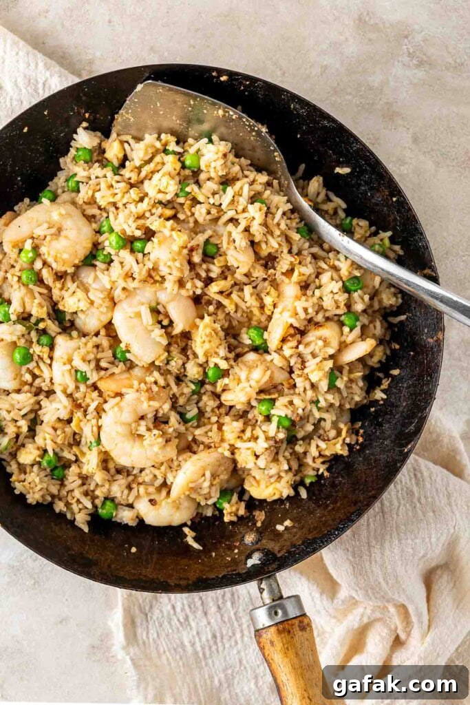 Garlic Prawn Egg Fried Rice Recipe for Quick Weeknight Meals 9 Prawn and egg fried rice with peas in a wok.