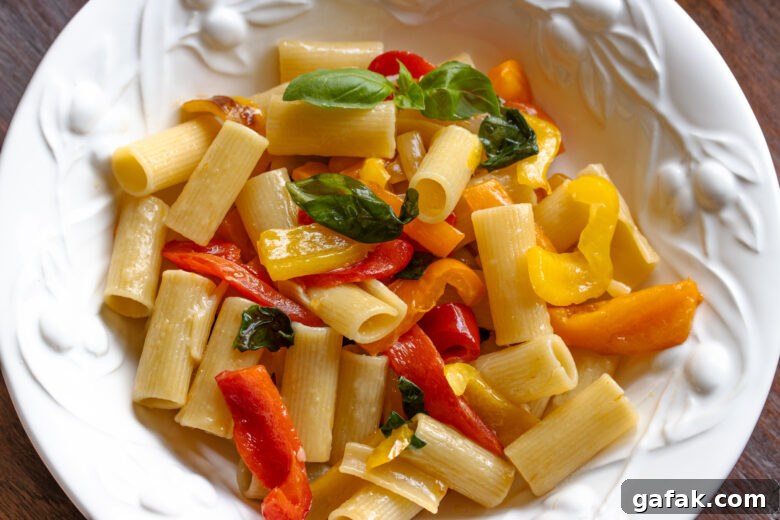 Roasted Red Pepper Sauce with Garlic, Basil & Pasta Recipe 4 Roasted bell pepper pepper sauce with pasta served in a white dish.
