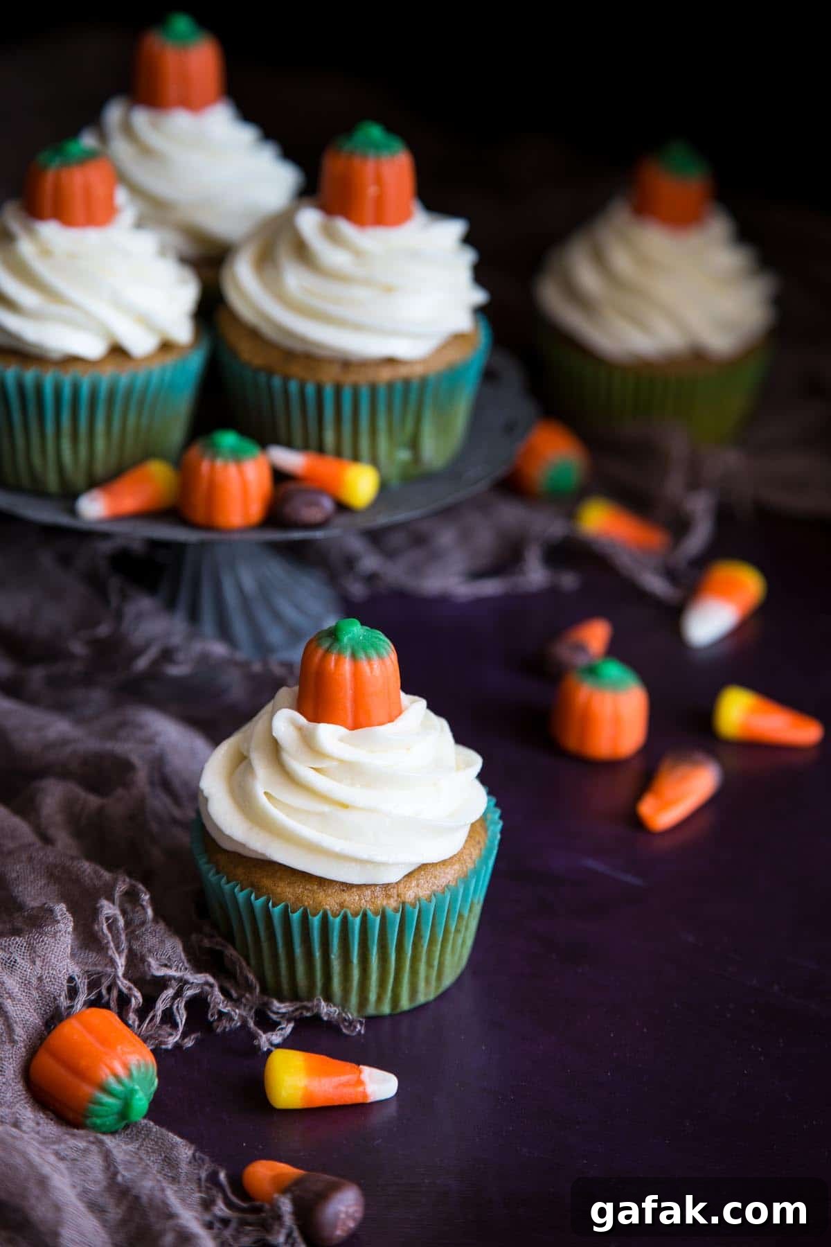 Pumpkin cupcakes with cream cheese frosting decorated with mellowcreme pumpkins.