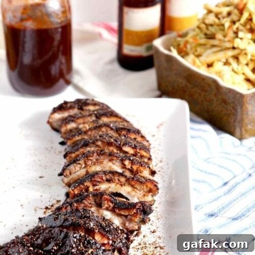 A platter of Memphis-Style Barbecue Ribs sits with barbecue sides on red, white and blue linen.