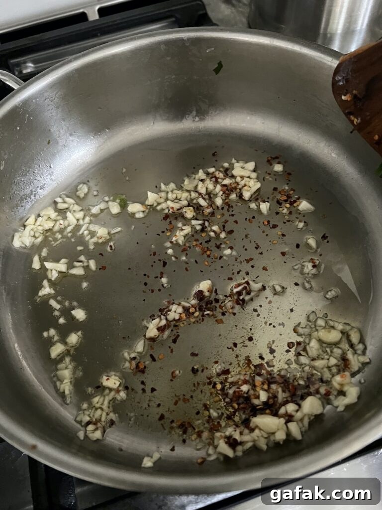 Browning garlic in olive oil in stainless steel pan.