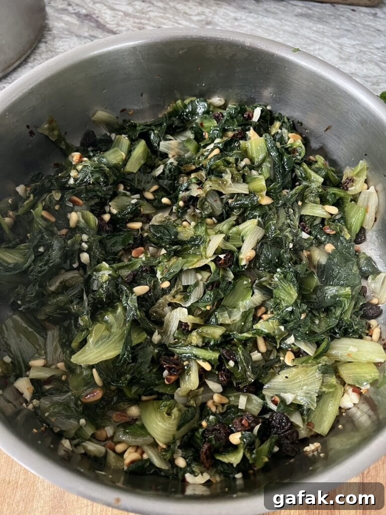 Finished sauteed escarole, italian style, in stainless steel pan.
