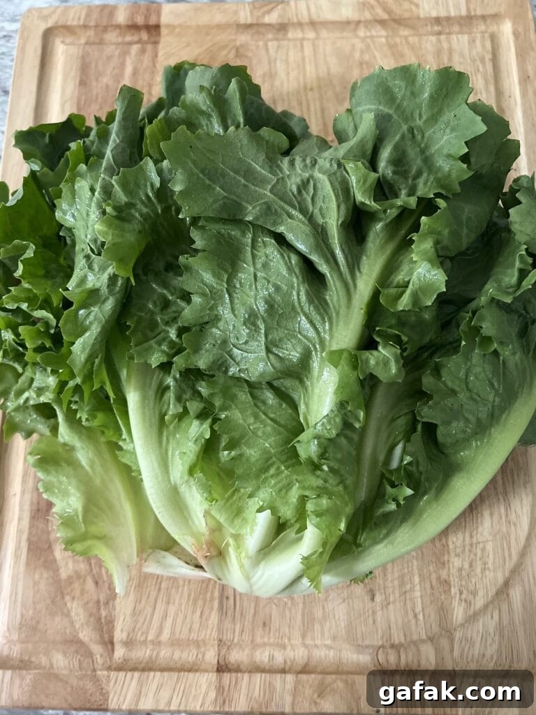 Large head of escarole on cutting board.