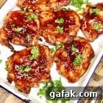 BBQ chicken thighs on a platter with parsley.