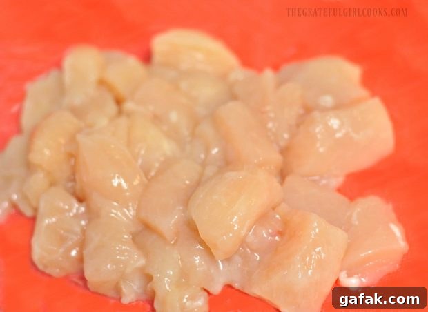 Chicken breasts are cut into cubes to cook for the chicken veggie stir fry.