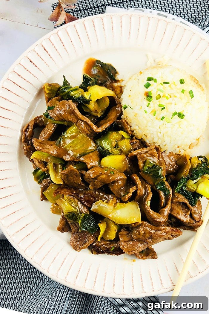 Instant Pot Ginger Beef Served in White Plate With Steamed Rice- Overhead Shot