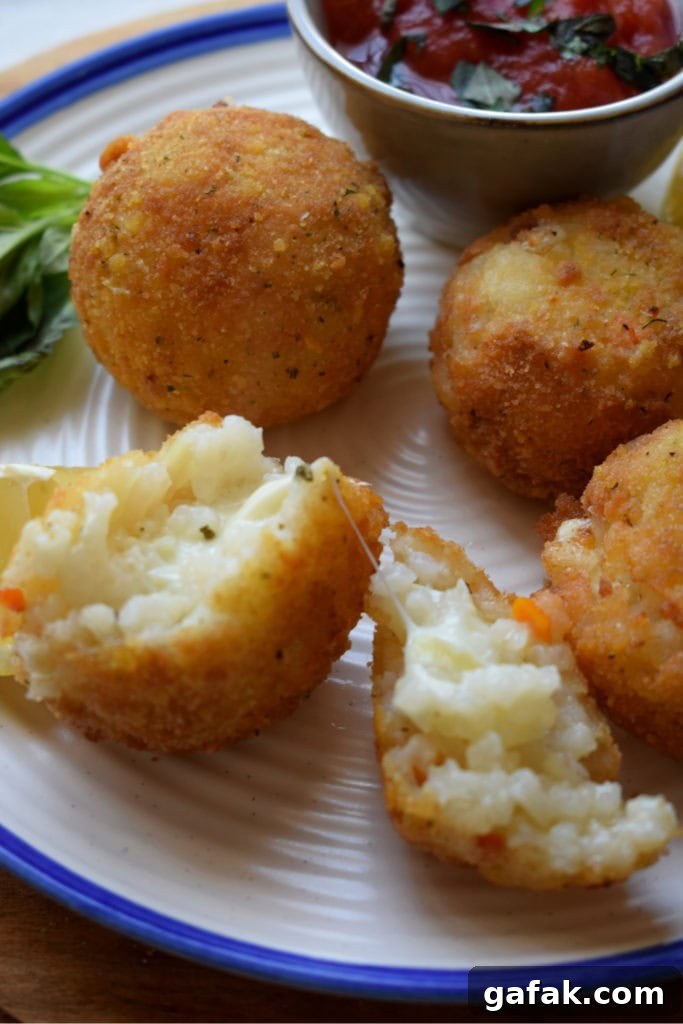 close up of arancini with a dipping sauce