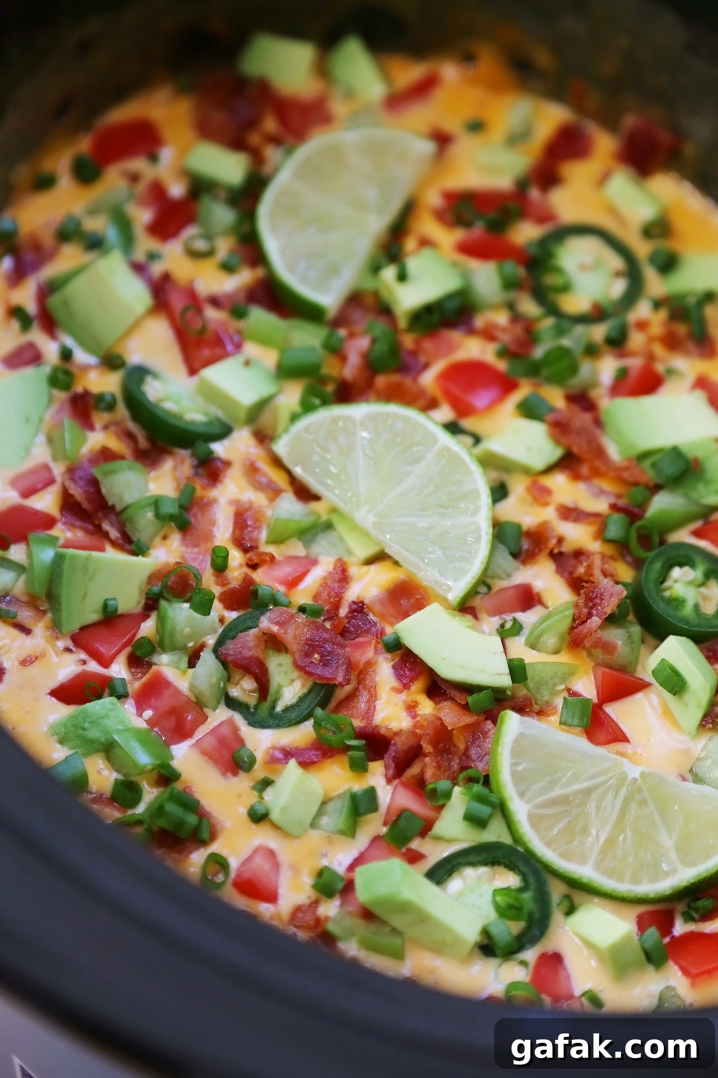 Creamy 2-Ingredient Slow Cooker Queso Dip for Parties 4 2-Ingredient CrockPot Queso Dip - So easy, cheesy and full of flavor for parties and lazy weekends in. Load it up with bacon, tomatoes, jalapenos and your favorite fixin's!