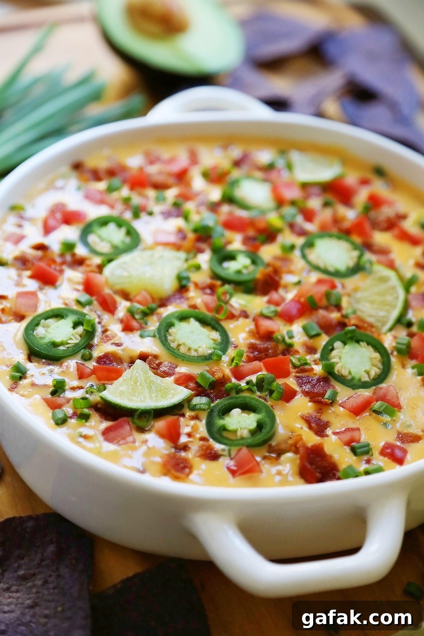 Creamy 2-Ingredient Slow Cooker Queso Dip for Parties 6 2-Ingredient CrockPot Queso Dip - So easy, cheesy and full of flavor for parties and lazy weekends in. Load it up with bacon, tomatoes, jalapenos and your favorite fixin's!