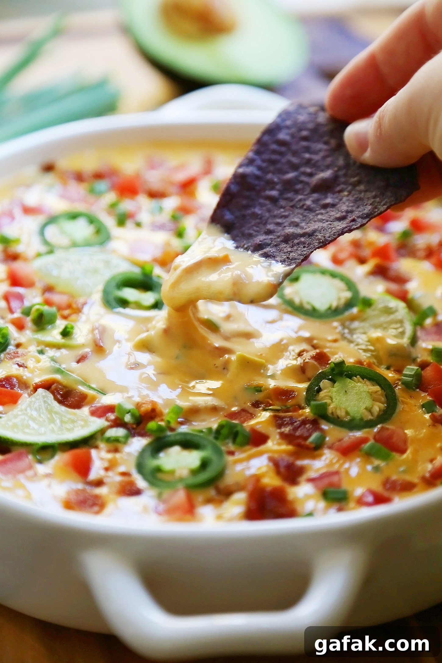 Creamy 2-Ingredient Slow Cooker Queso Dip for Parties 7 2-Ingredient CrockPot Queso Dip - So easy, cheesy and full of flavor for parties and lazy weekends in. Load it up with bacon, tomatoes, jalapenos and your favorite fixin's!