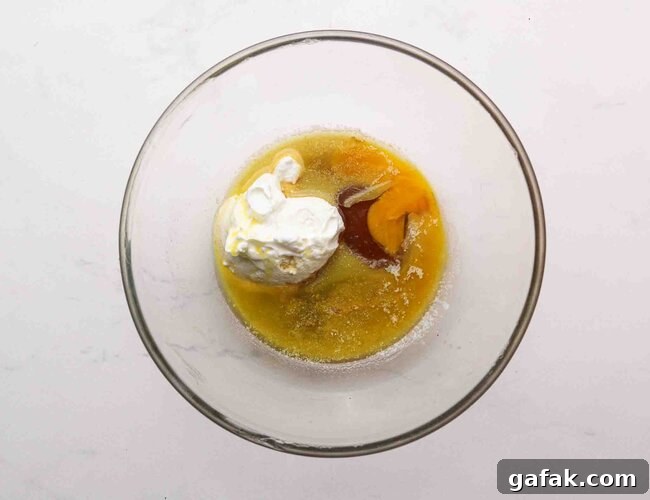 Yogurt, egg, butter, and syrup in a bowl.