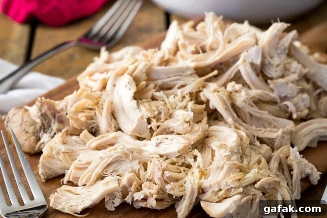 A cutting board loaded with juicy shredded chicken