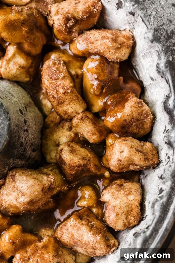 cinnamon roll chunks in bundt pan with pecan caramel sauce