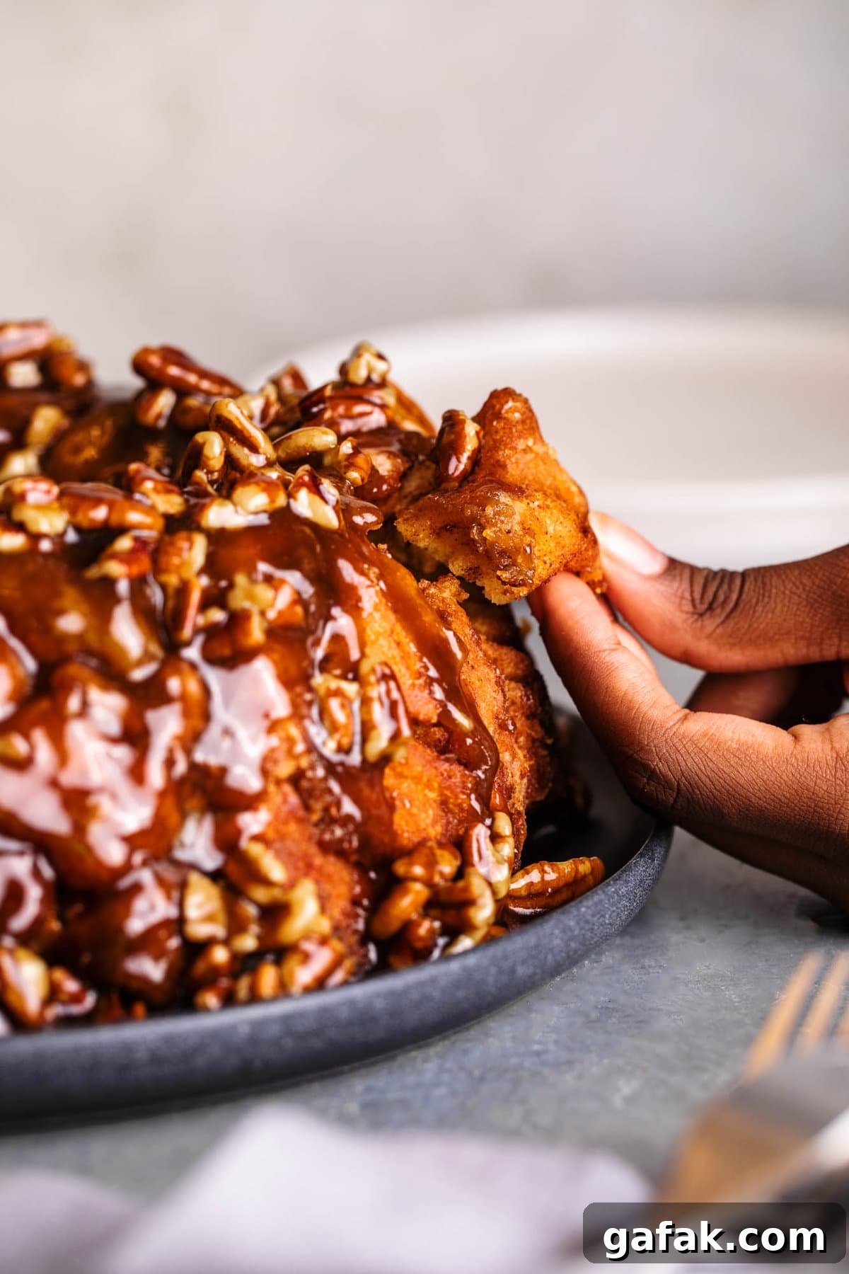 pulling a piece of cinnamon roll monkey bread