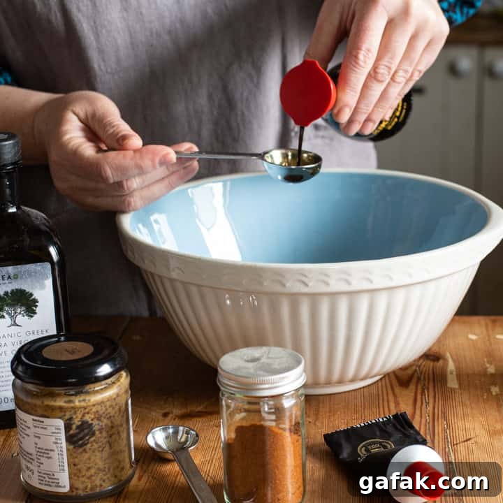 Sticky Honey Chicken Wings Recipe: Crispy Baked or Fried Wings 4 woman in grey pouring soy sauce from a bottle into a measuring spoon over a blue mixing bowl
