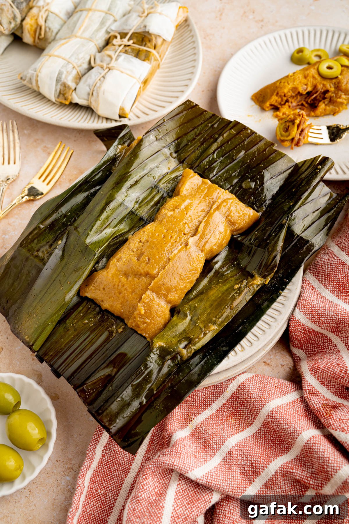 Unwrapped pasteles on a banana leaf on top of a plate after cooking.
