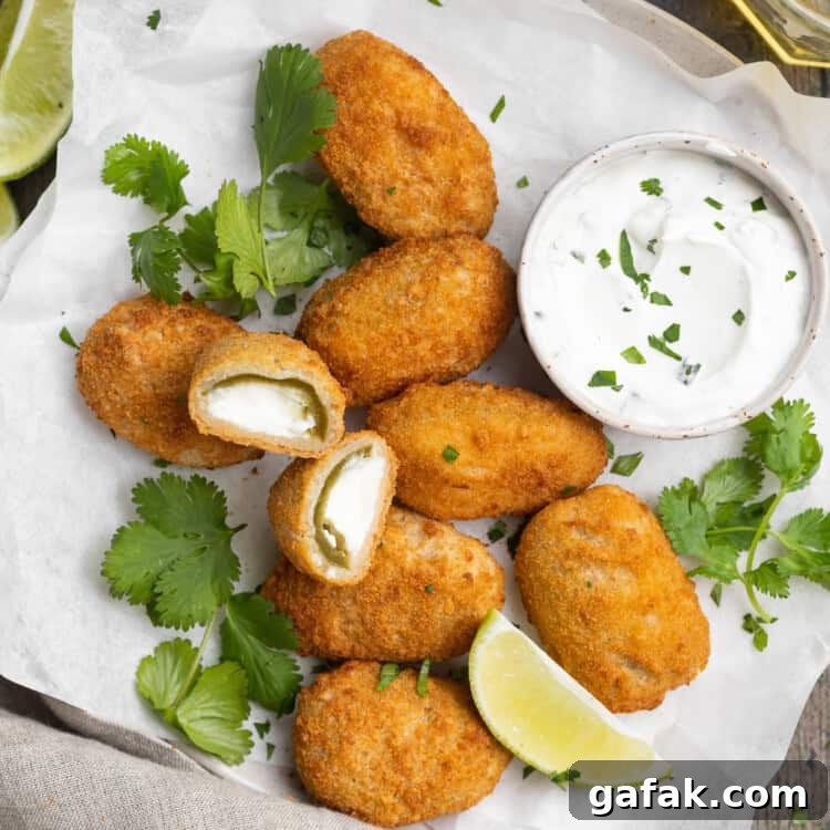 overhead image of air fryer frozen jalapeno poppers on a plate with cilantro lime dipping sauce on the side