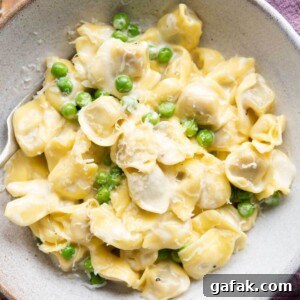 Creamy Tortellini in Parmesan Sauce 7 A close up of Tortellini alla Panna in a bowl with peas