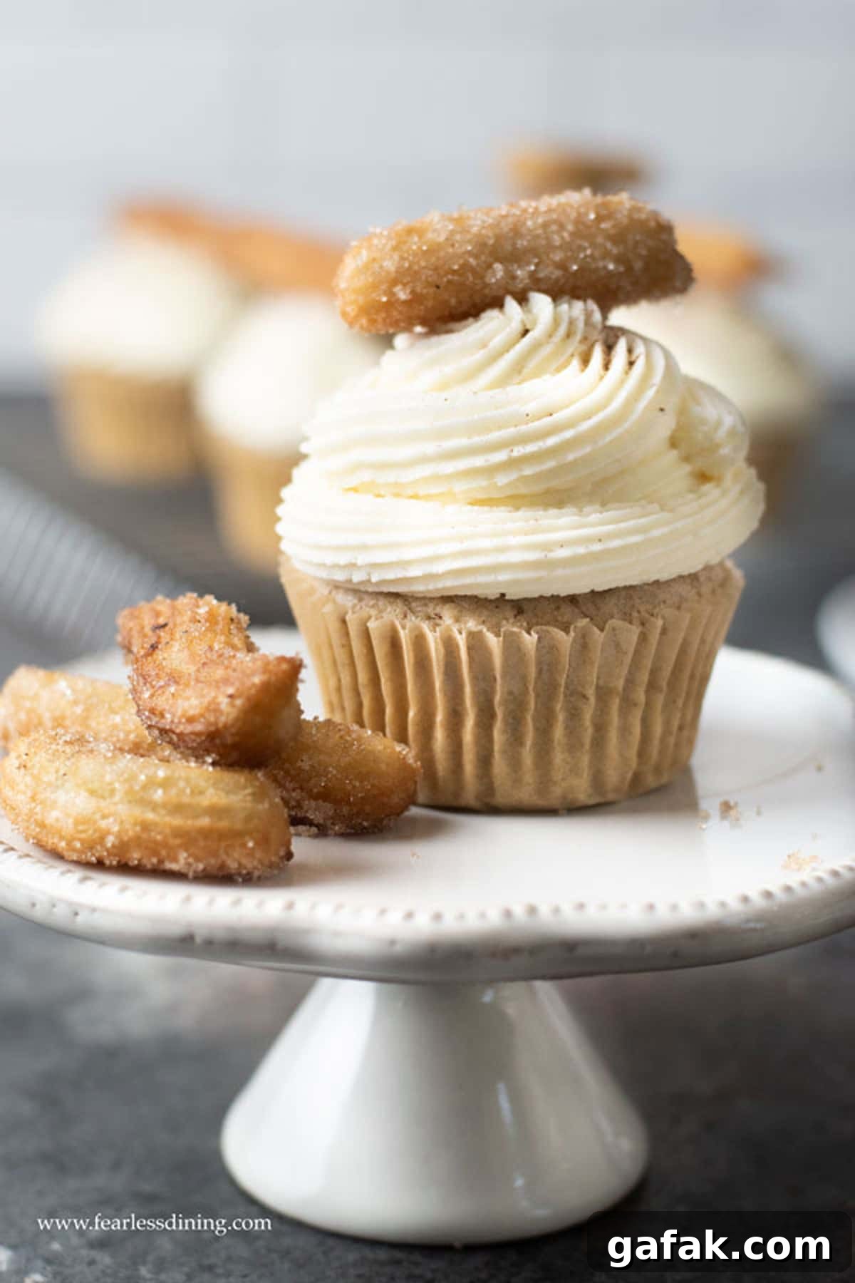 A churro cupcake on a cupcake stand.