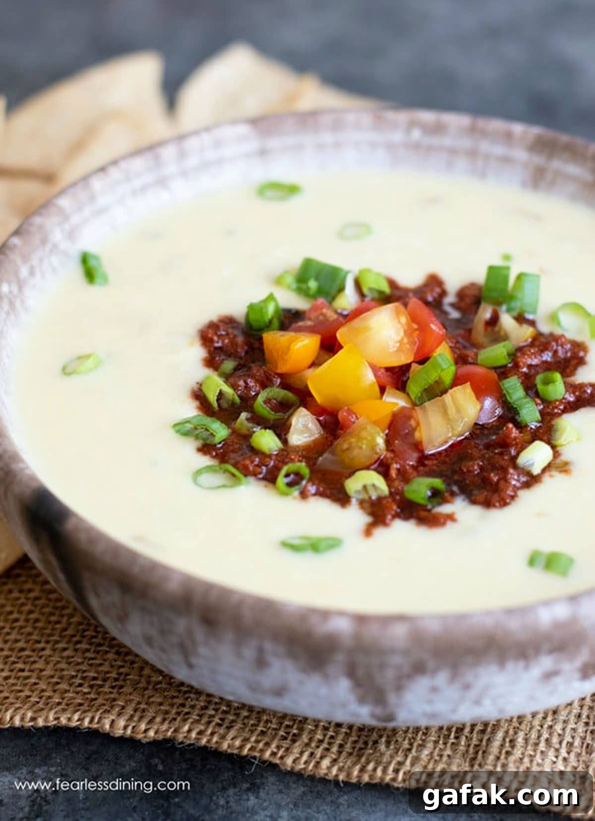 A close up of a bowl of stuffed white queso dip in a bowl.
