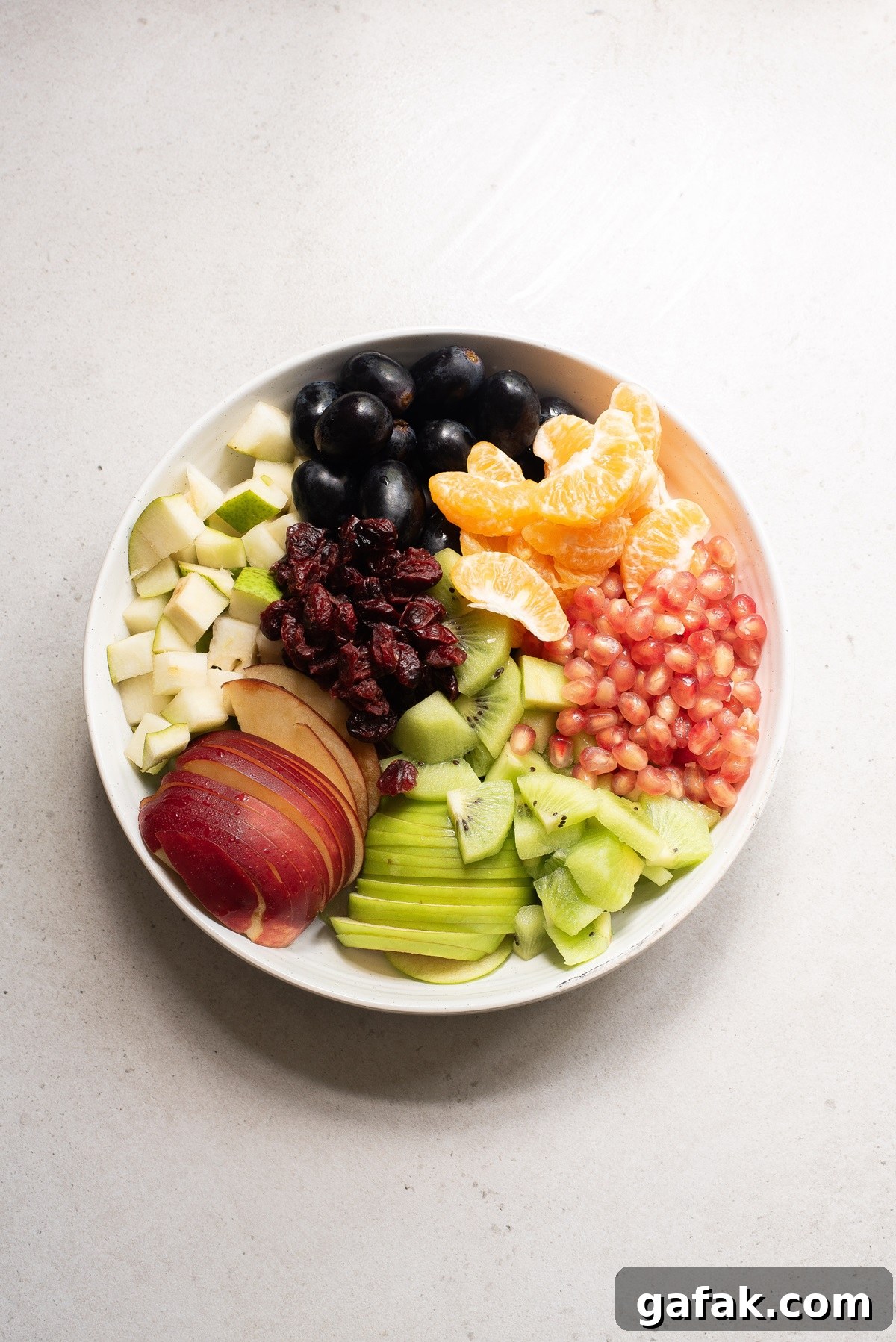 Fruit sliced or diced on a white plate.