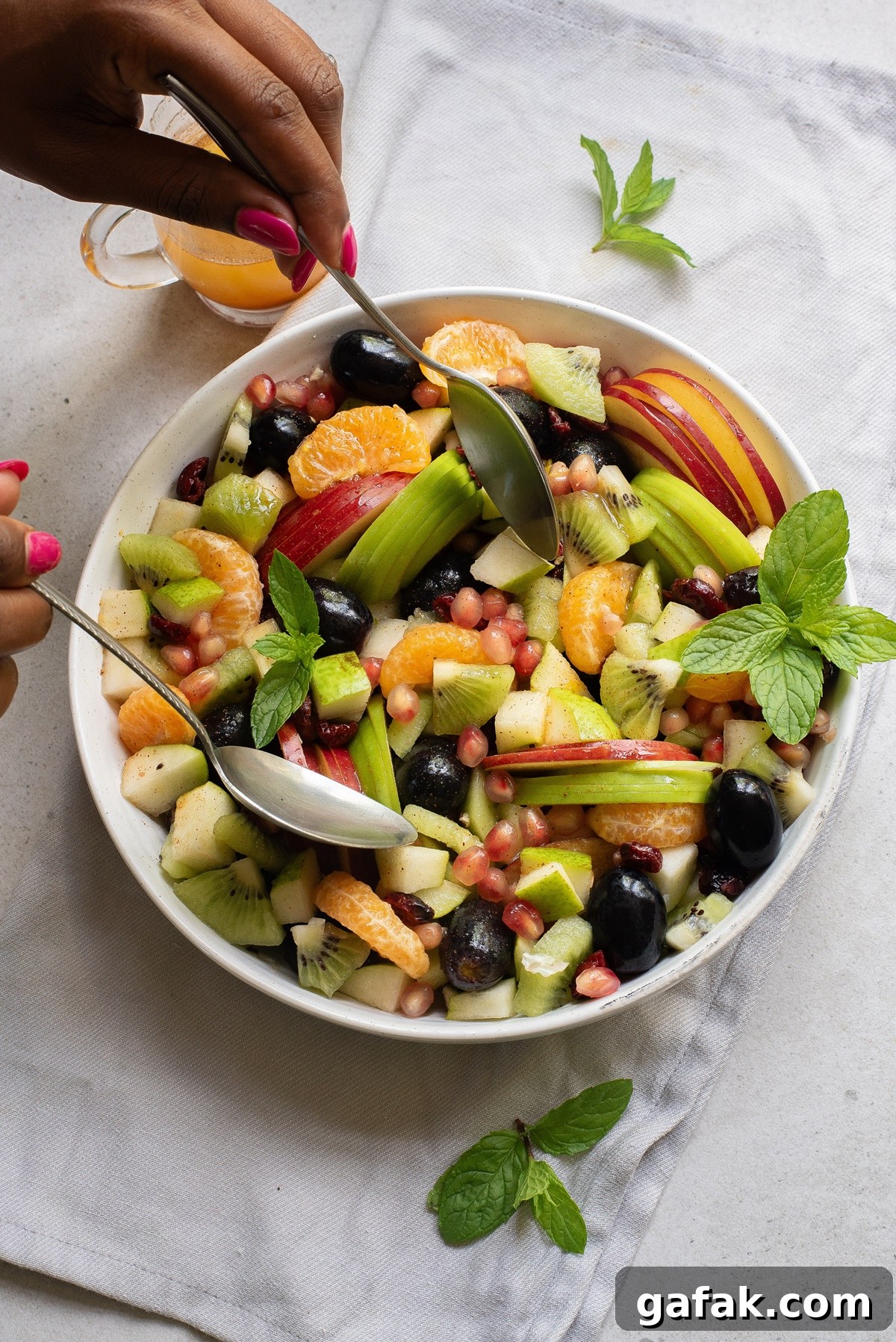Fruit being mixed with spoon.
