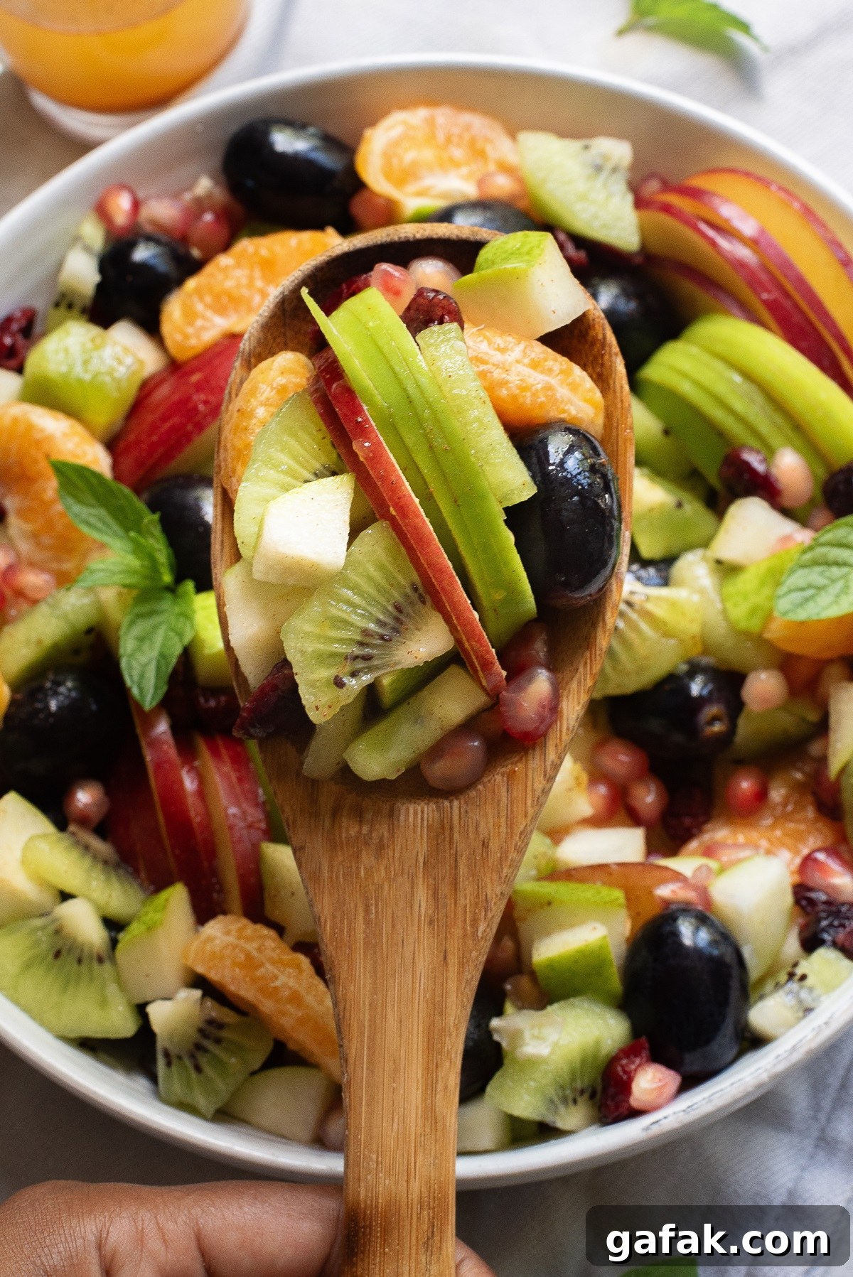 Close up view of fruit on a wooden spoon.