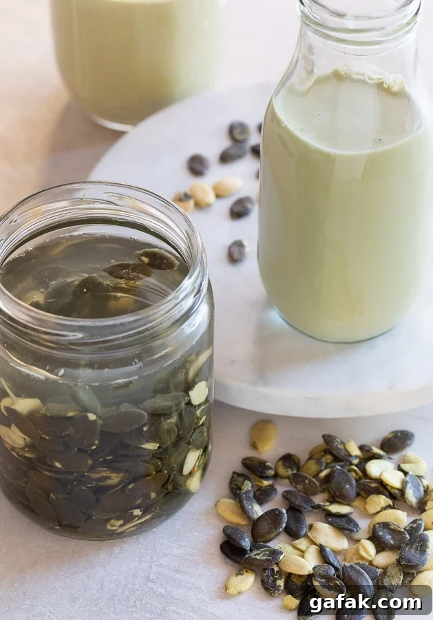 Pale green pumpkin seed milk in a jar with a jar of seeds soaking in water.