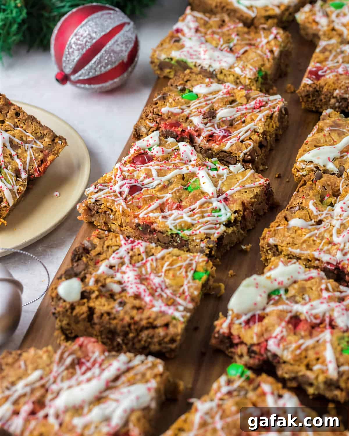 iced christmas 7 layer magic bars on a wooden cutting board.