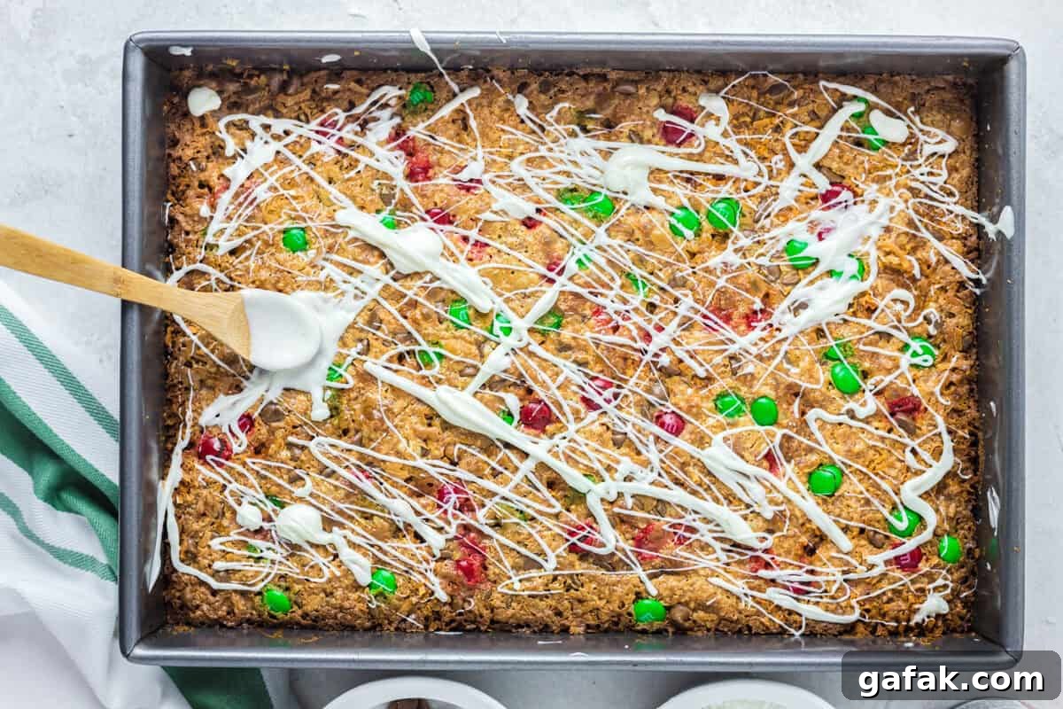 drizzling white chocolate onto magic cookie bars in a baking pan