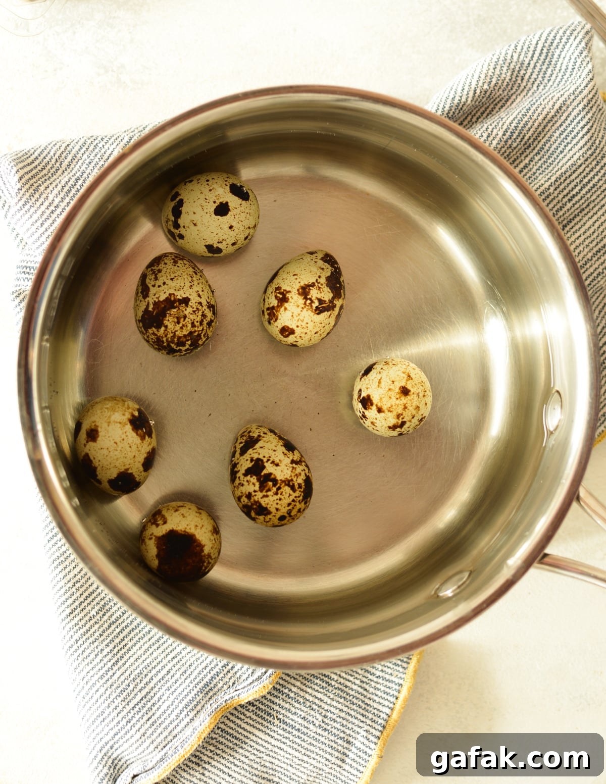 a saucepan with water and quail eggs