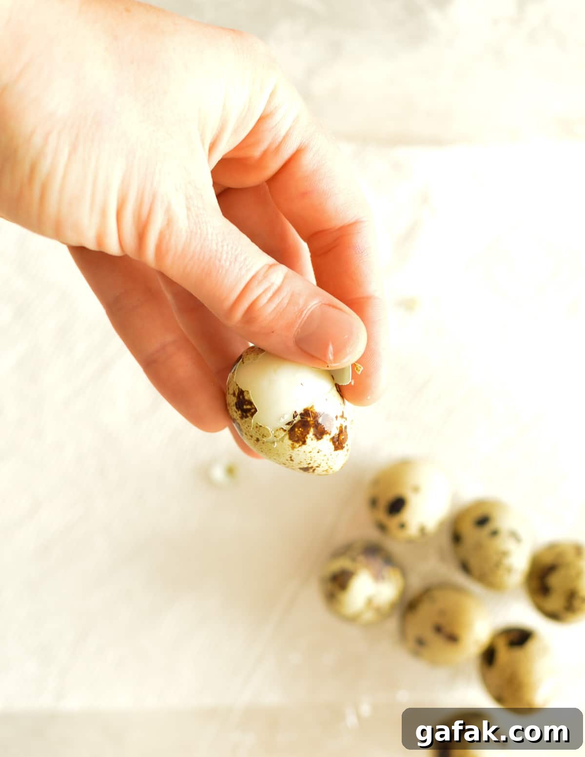 hand peeling a quail egg
