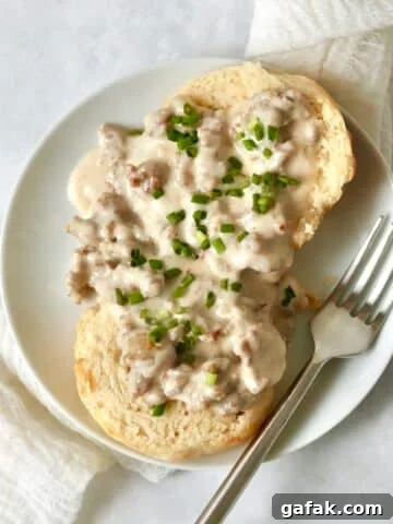 Single serve biscuits and gravy on a small plate.