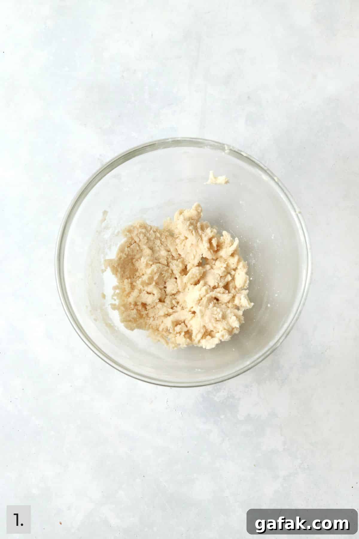 Butter mixed with powdered sugar, vanilla, and flour in a bowl.