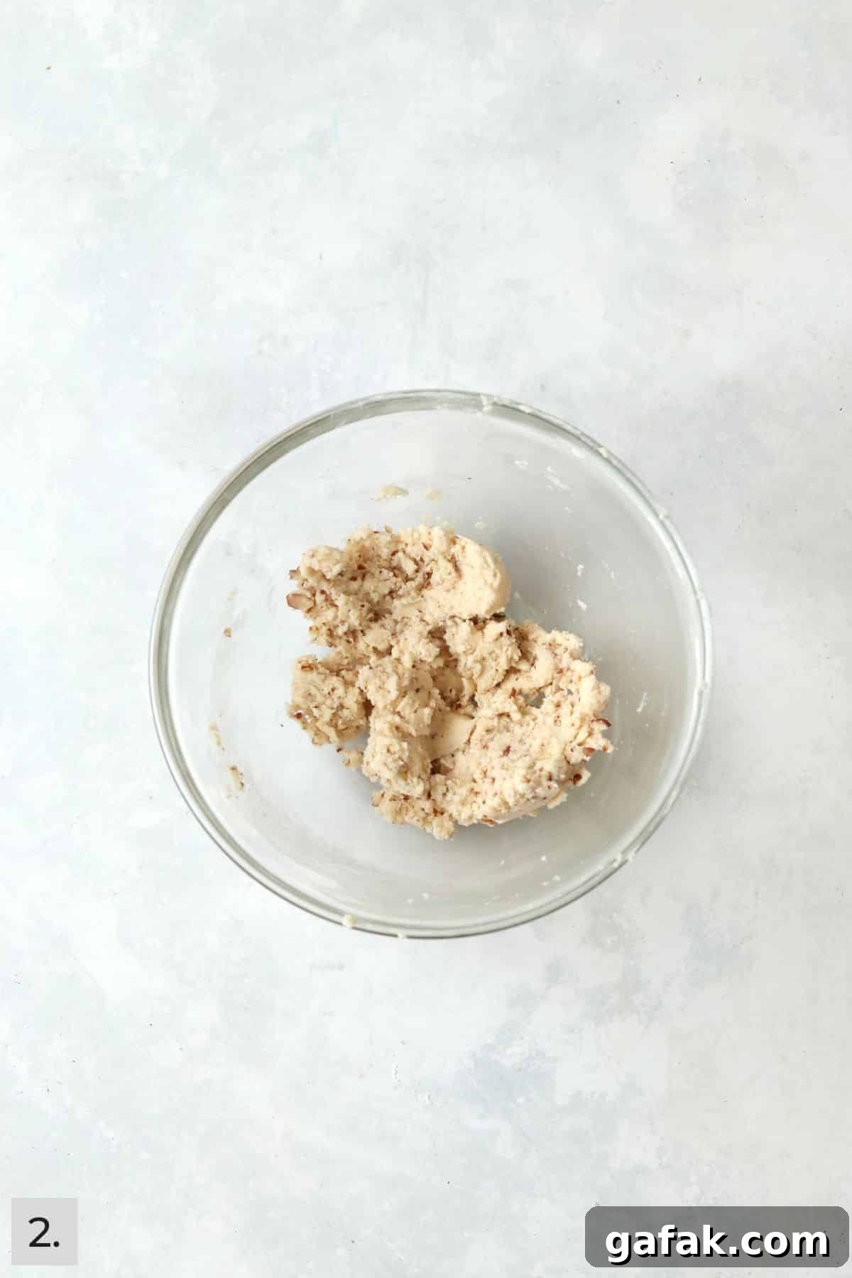 Small batch of snowball cookie dough in a bowl.