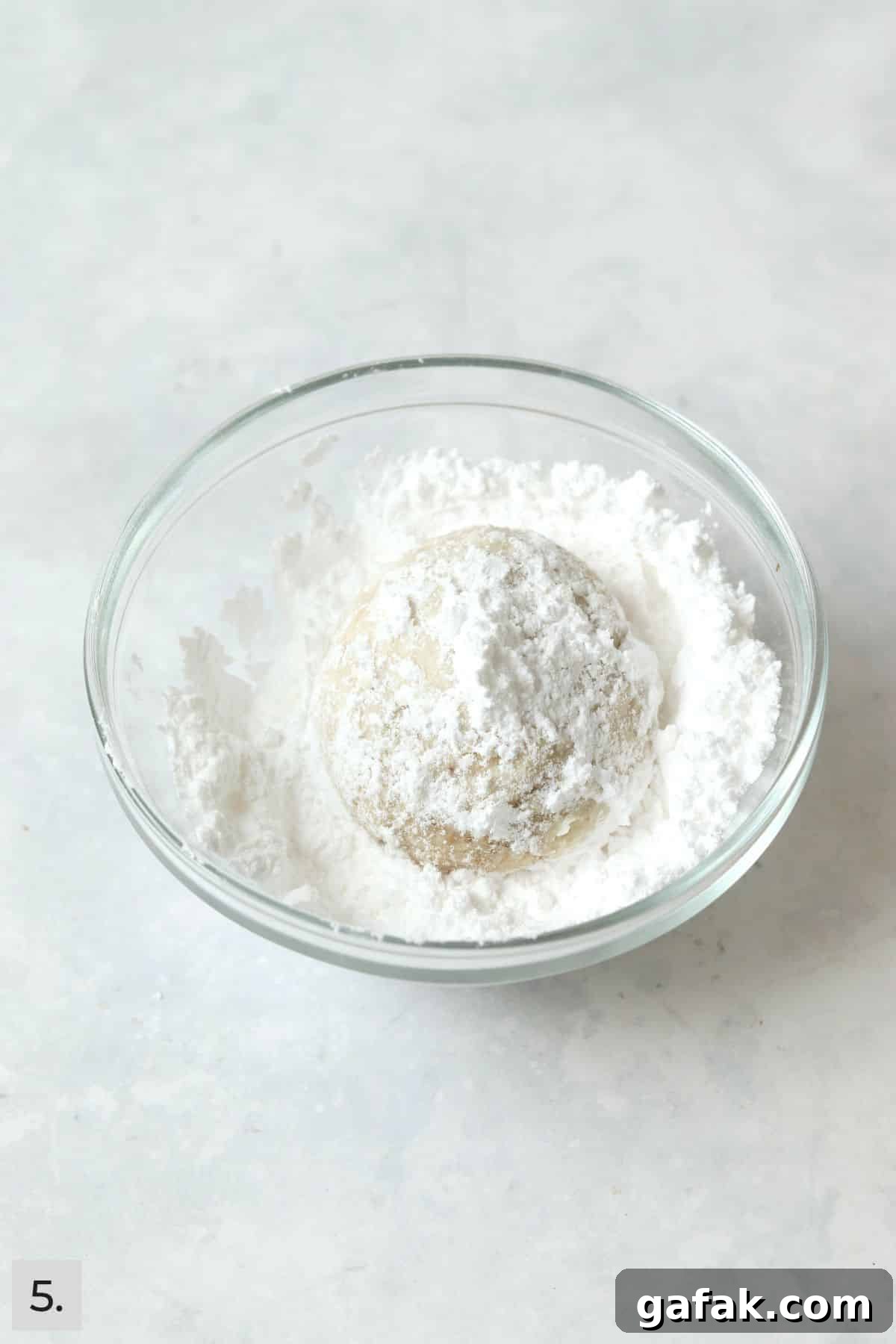 Baked snowball cookie rolled in powdered sugar.