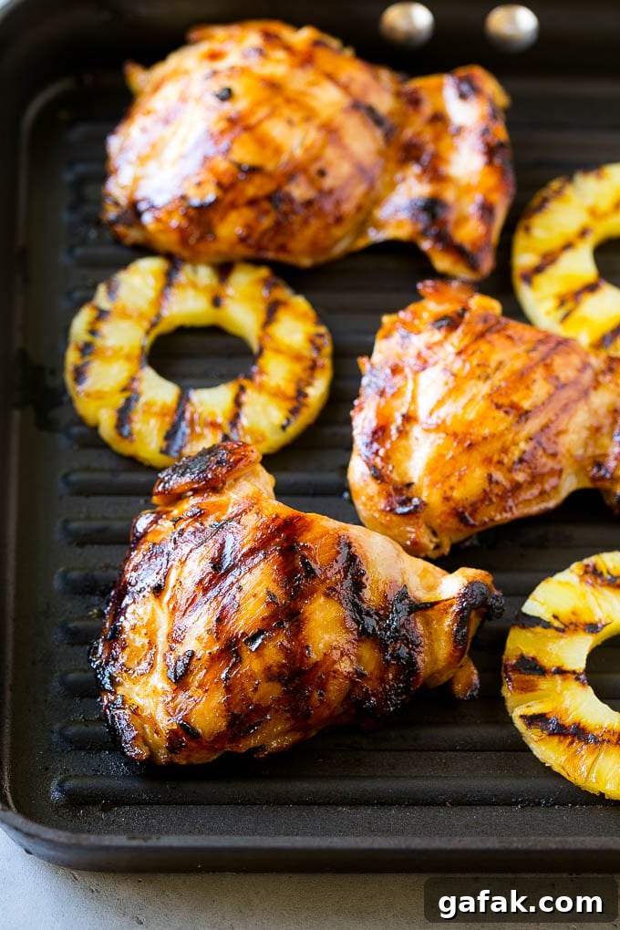 Chicken thighs and pineapple slices on a grill pan. Chicken thighs and pineapple slices on a grill pan.