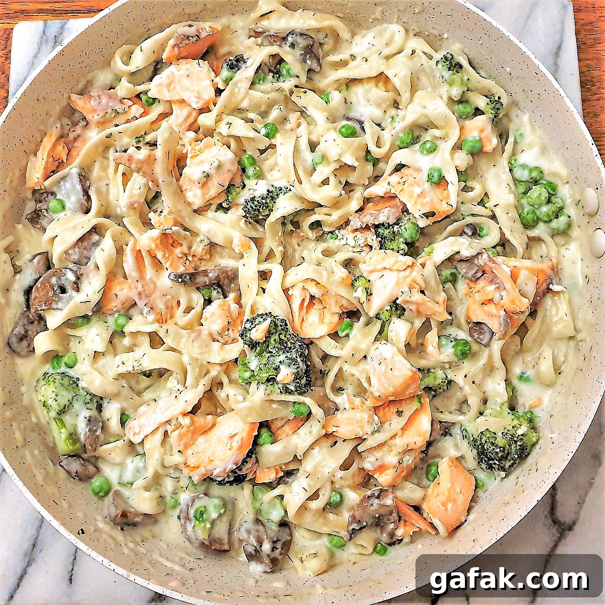 Salmon and broccoli pasta in a frying pan.