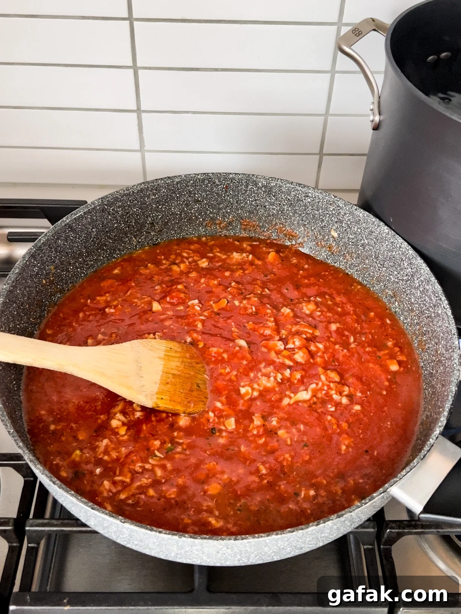 A pan on a stove with sauce in it.
