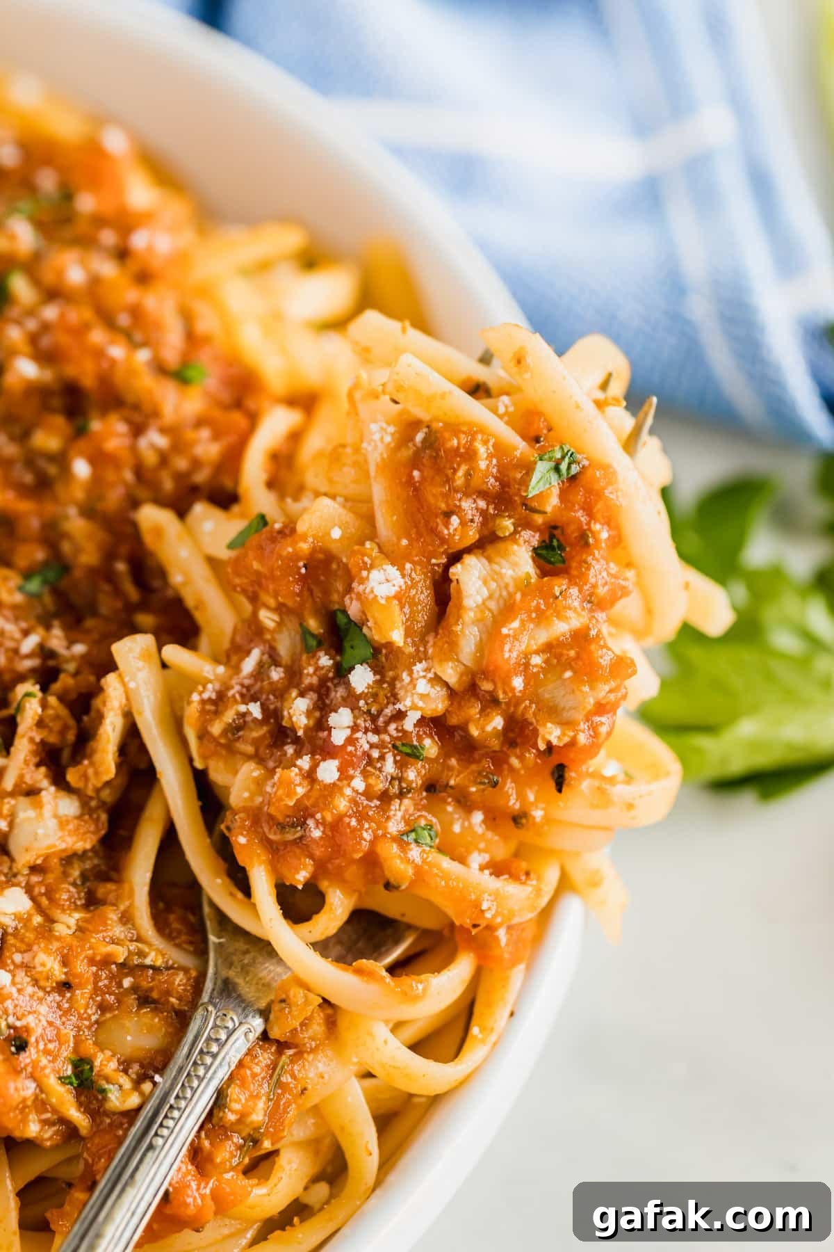 A close up image of a fork with linguine and clam sauce twirled onto it.