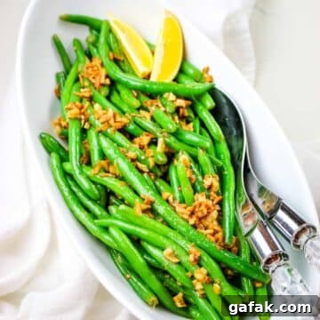 green beans with sauteed garlic and lemon wedges.