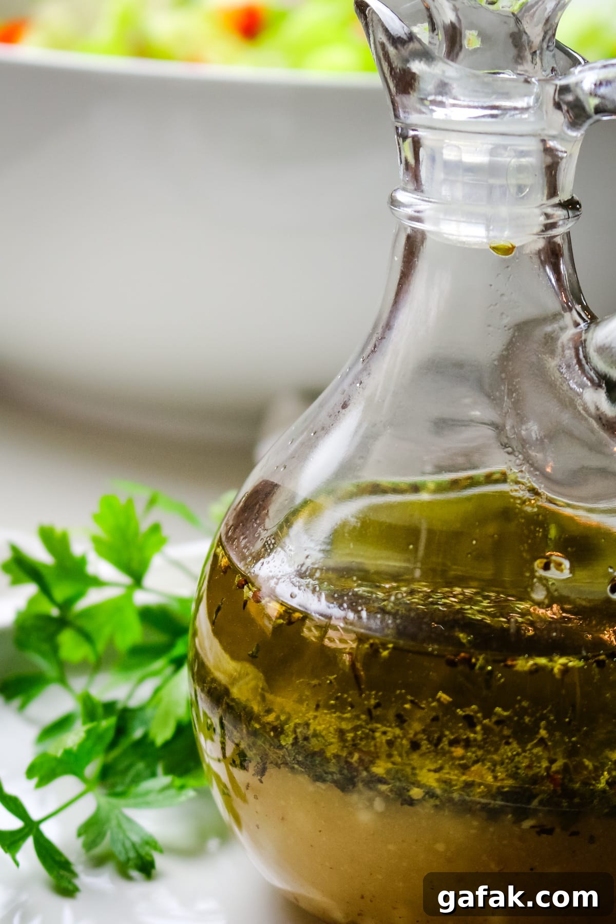 closeup of Greek salad dressing with fresh parsley on the side.