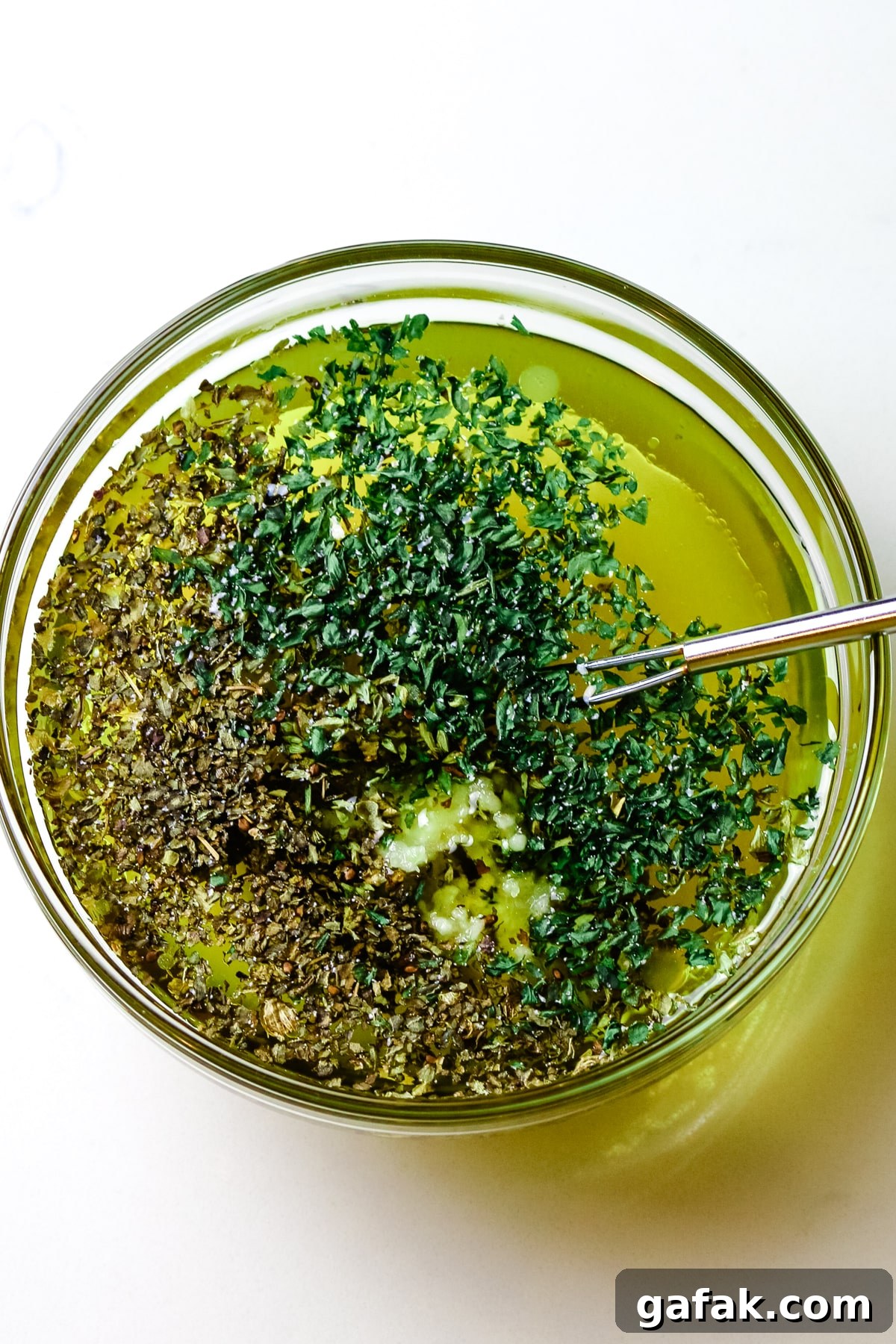 olive oil, herbs, and garlic in a small dish.
