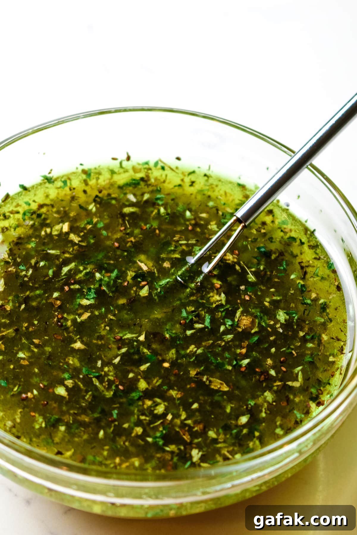 whisked salad dressing in a clear dish.
