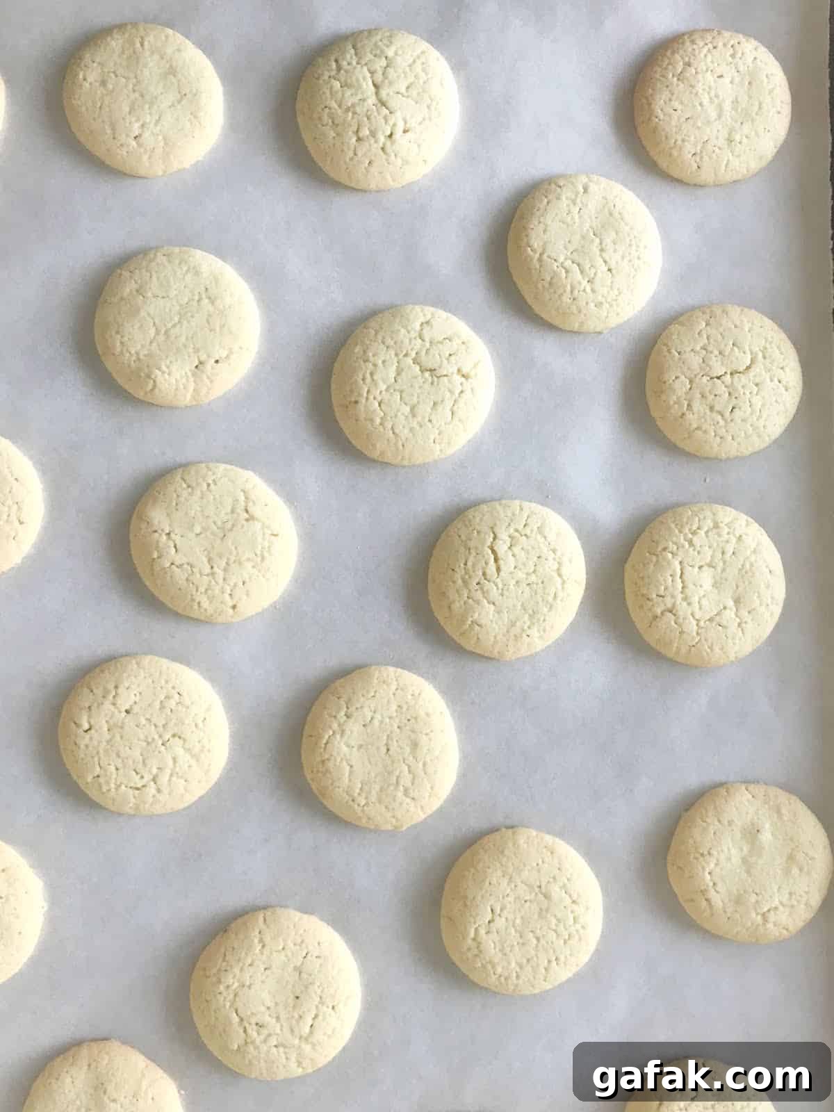 Baked cornstarch cookies on white parchment paper.